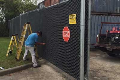 Sentry technician repairing a chain link gate.