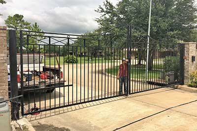 Worker finishing up an iron gate Houston TX service call.