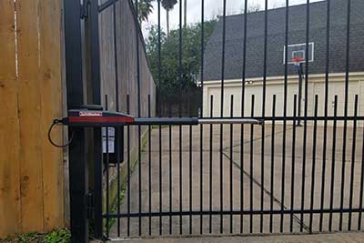 LiftMaster gate opener installed on iron gate at end of driveway.