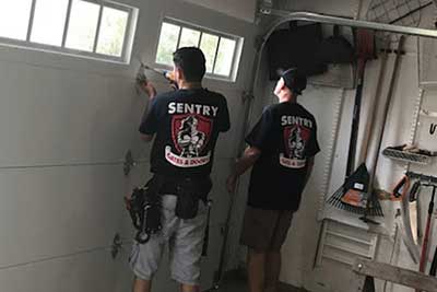 Garage door repair men working.