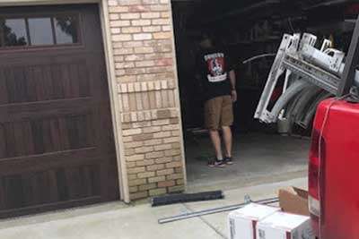Repairing a garage door in Houston, TX.