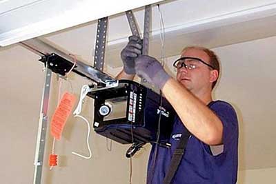 Man performing garage door opener repair.