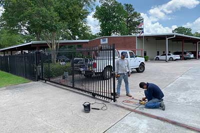 Men repairing a gate opener in Houston.