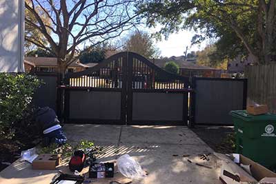 Man repair a wood driveway gate.