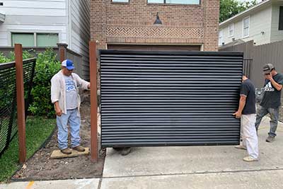 Men repairing a garage door in Houston, TX.