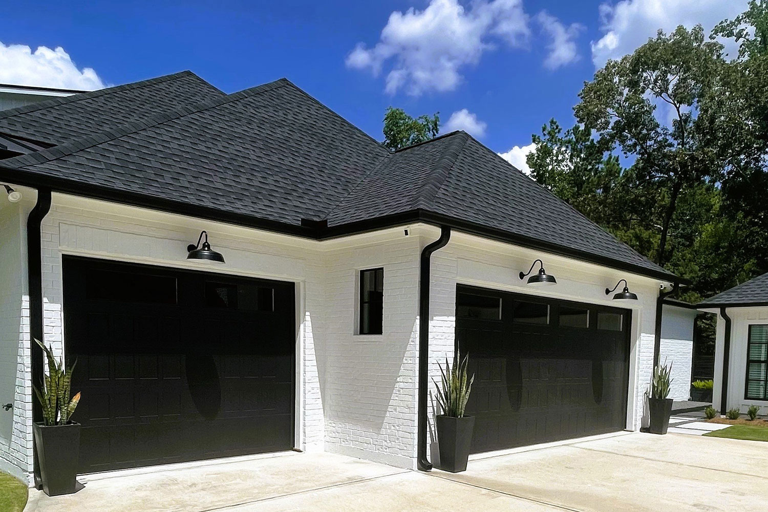 Two bay custom residential garage door with decorative security lamps installed in Houston.